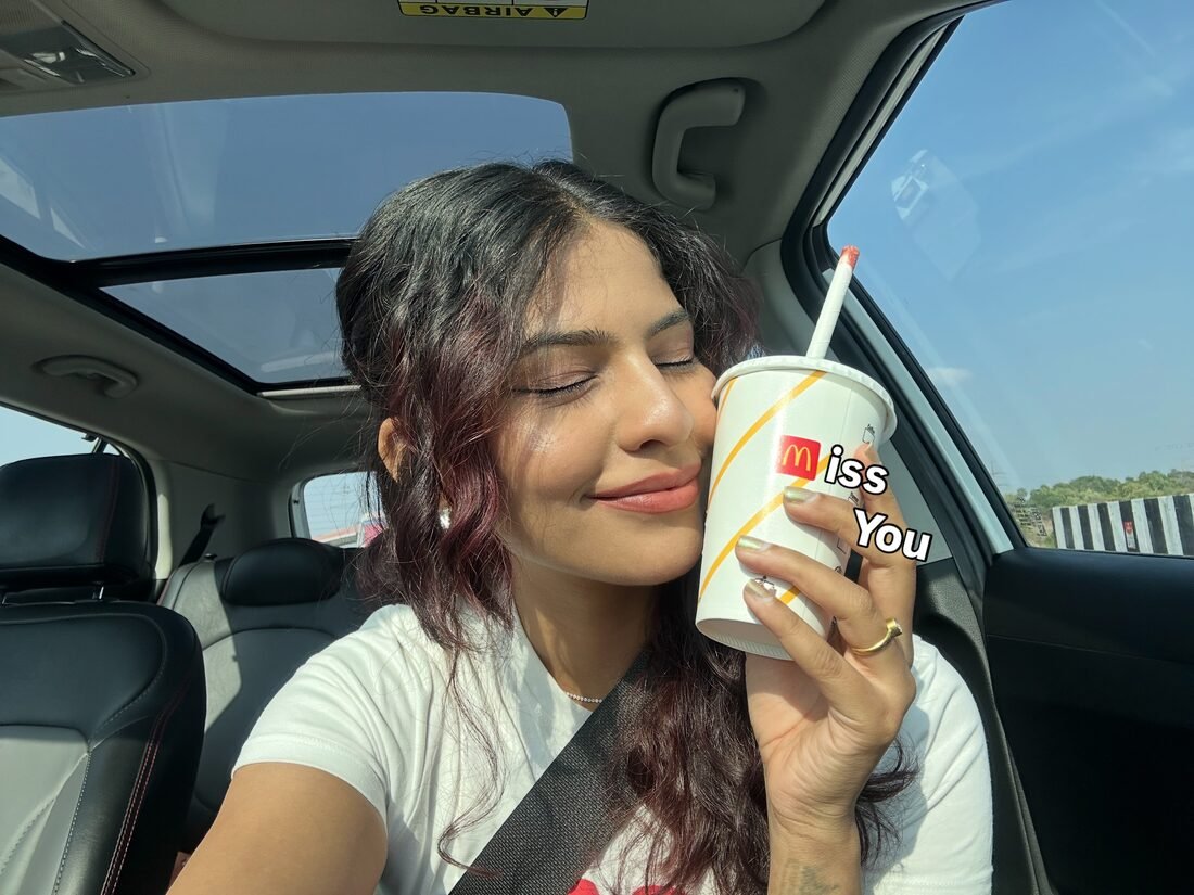 Shreya Jadhav holding a branded drink cup in a car